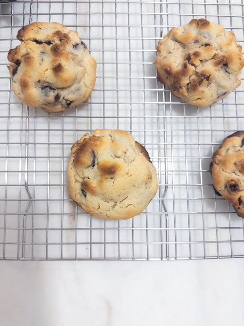 Freshly baked chocolate chip walnut cookies cooling on a wire rack