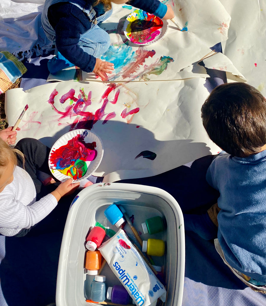 Toddlers painting on paper during a birthday party activity