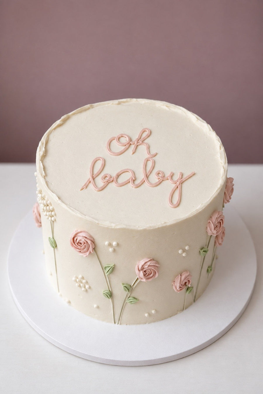 White cake with hand-piped pink roses