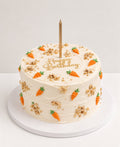 Carrot birthday cake with piped carrots, walnuts and a gold happy birthday topper