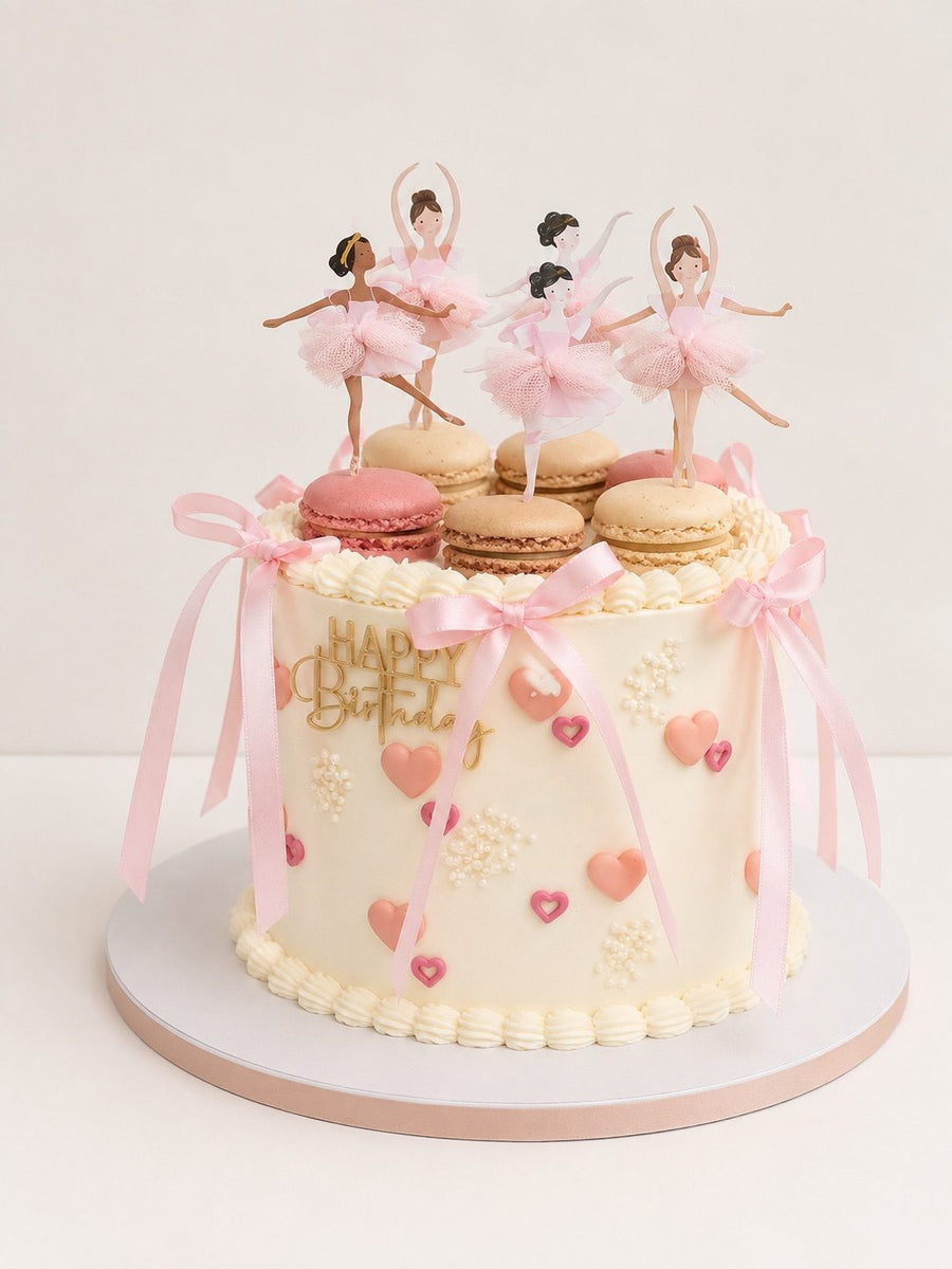 Cream cake with pink bows, macarons and ballerina paper toppers