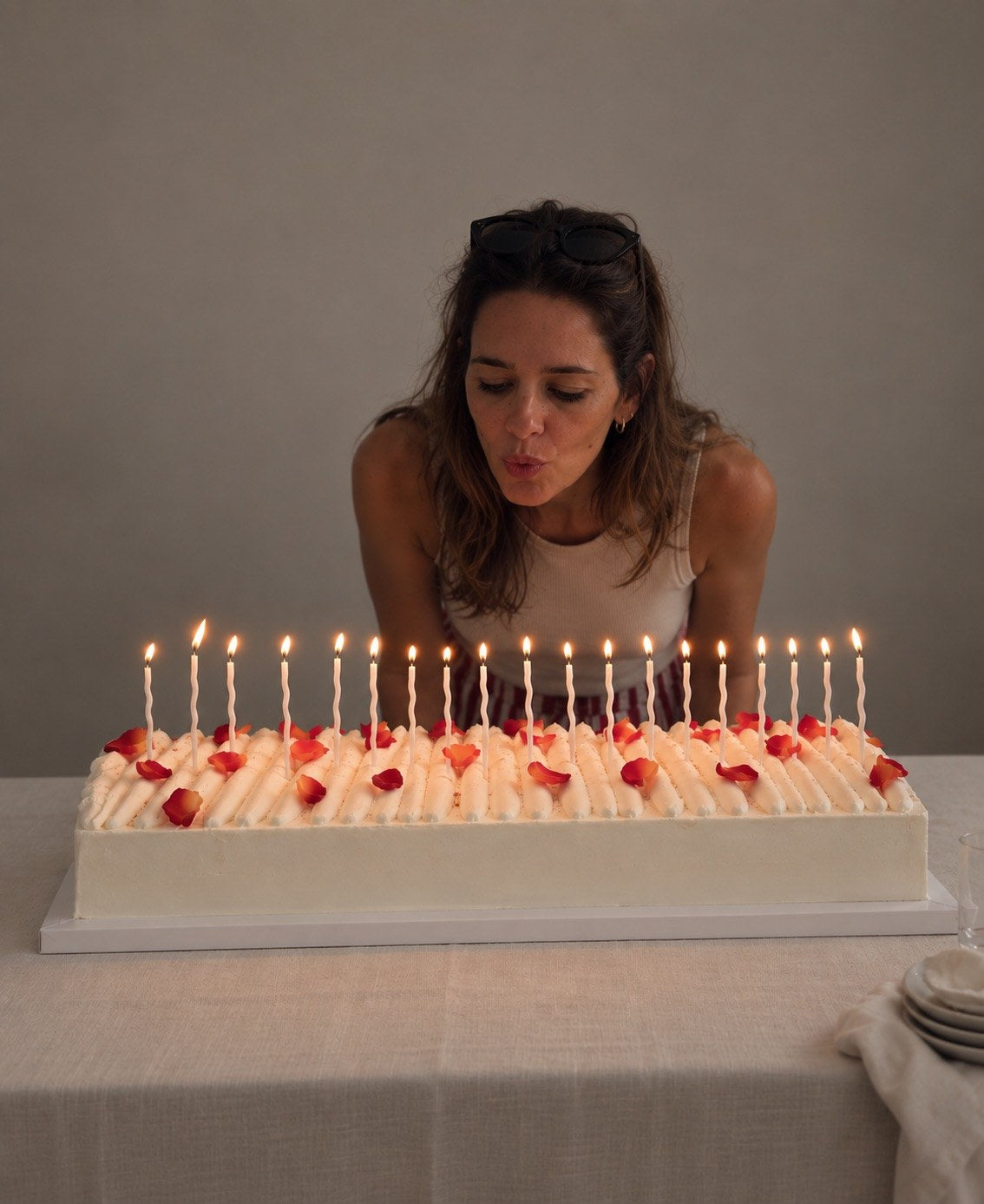 Susana blowing out candles on a long rectangular cake