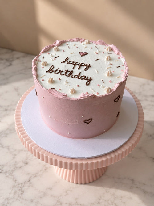 Mini 4-inch pink birthday cake with piped happy birthday script