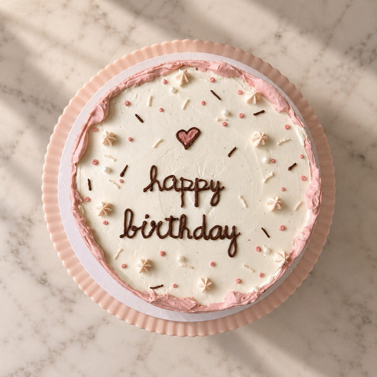 Top view of the mini pink cake with piped happy birthday script