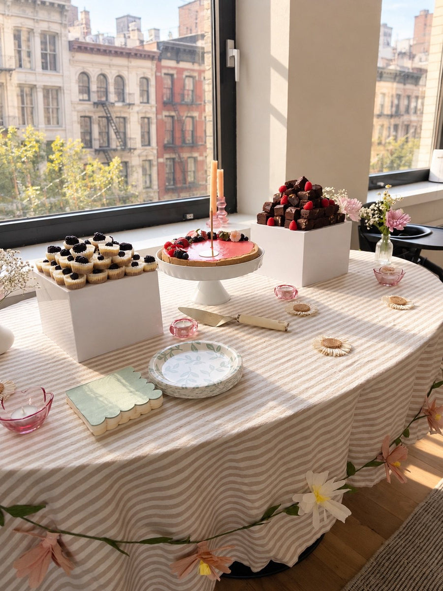 Styled party table with a striped cloth and flowers