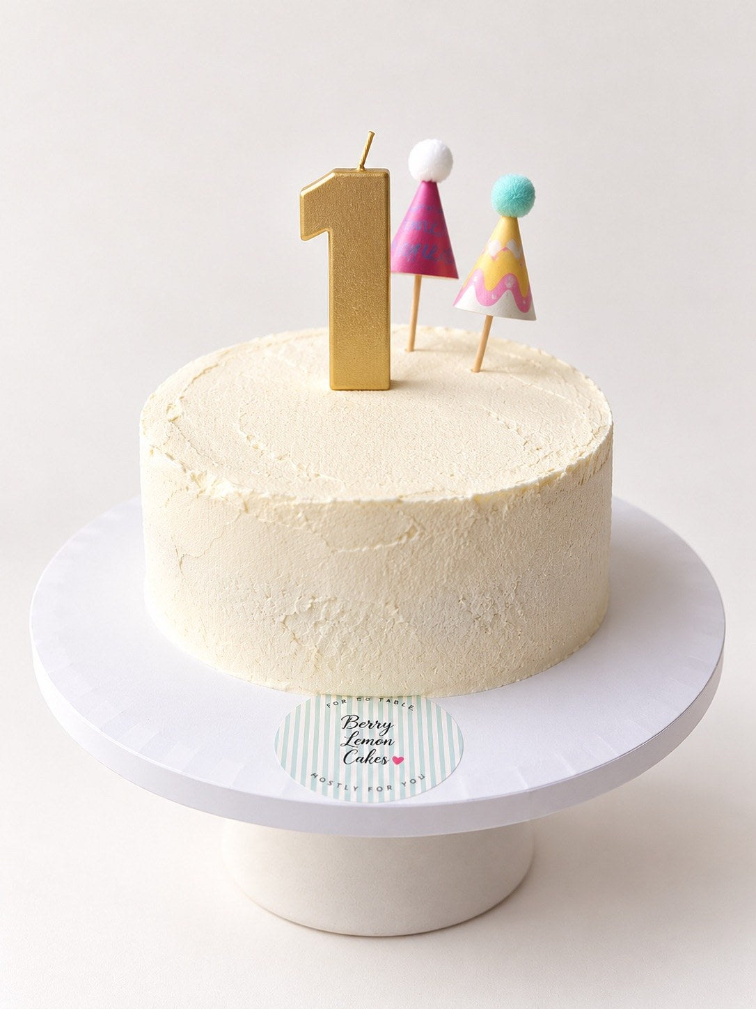 First birthday smash cake with gold 1 candle and paper party hats